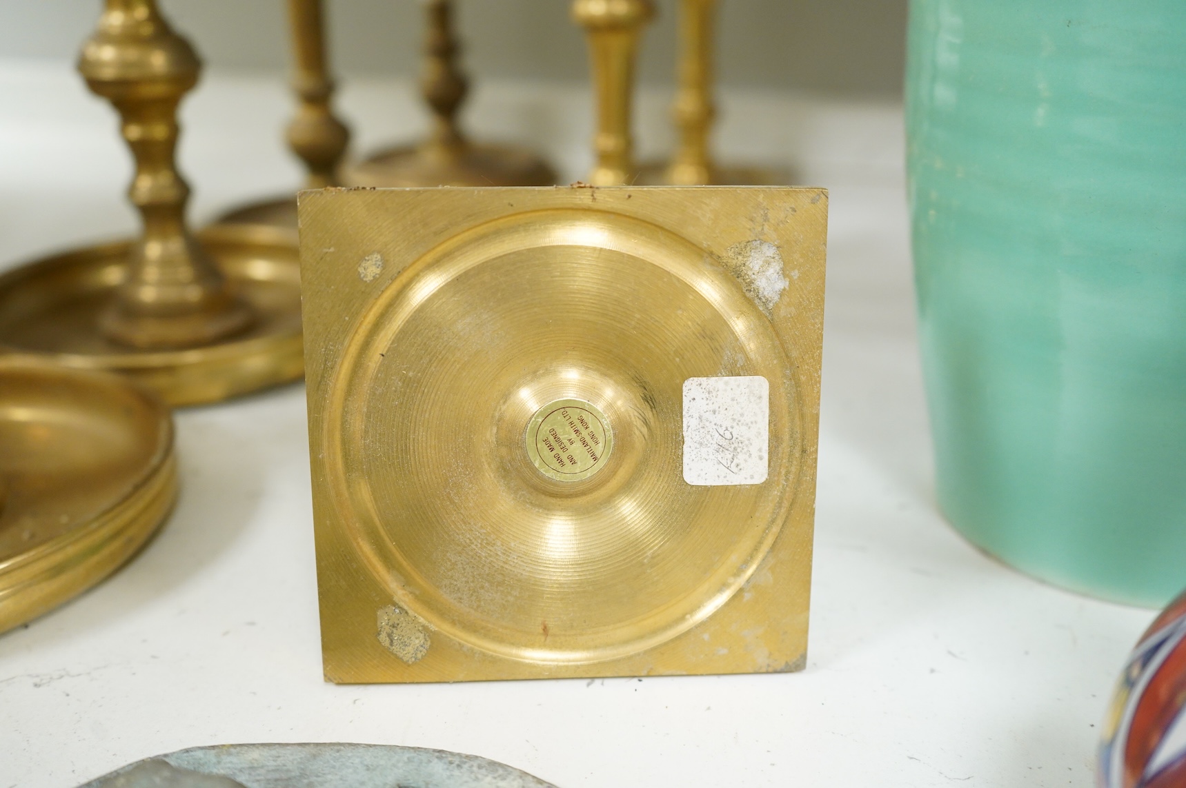Two fire marks and a collection of brass candlesticks, tallest 25.5cm